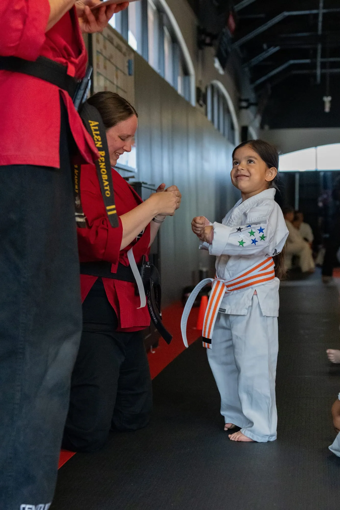 Big Ninjas student in a white gi with blue belt executing a kick against a focus pad held by an instructor at Guido's Martial Arts Academy in Clovis, CA