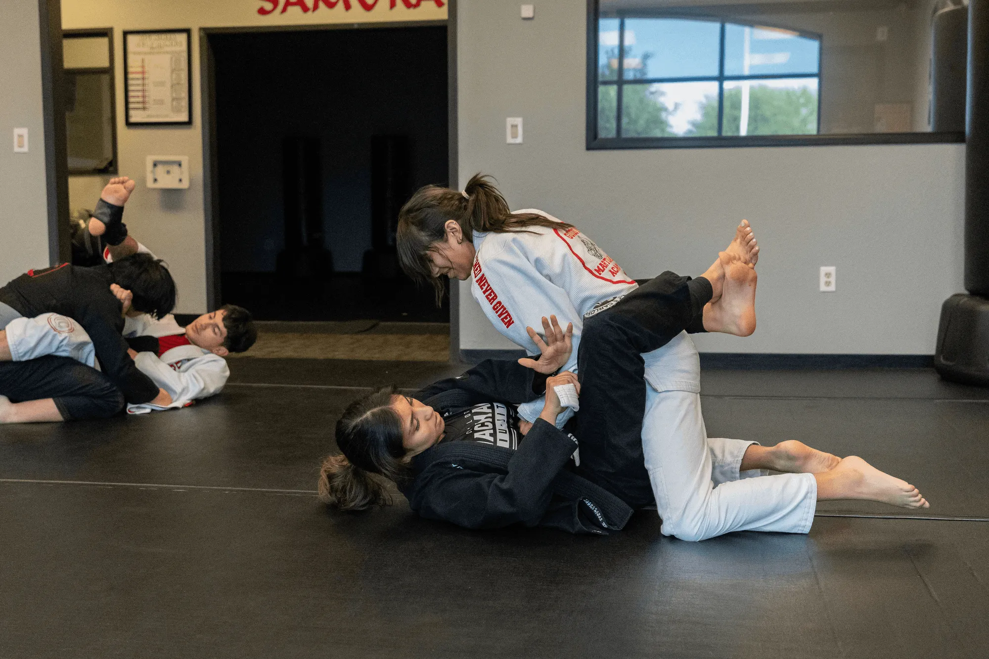 A folded white BJJ gi and worn blue belt on the mat at Guido's Martial Arts Academy in Clovis, CA
