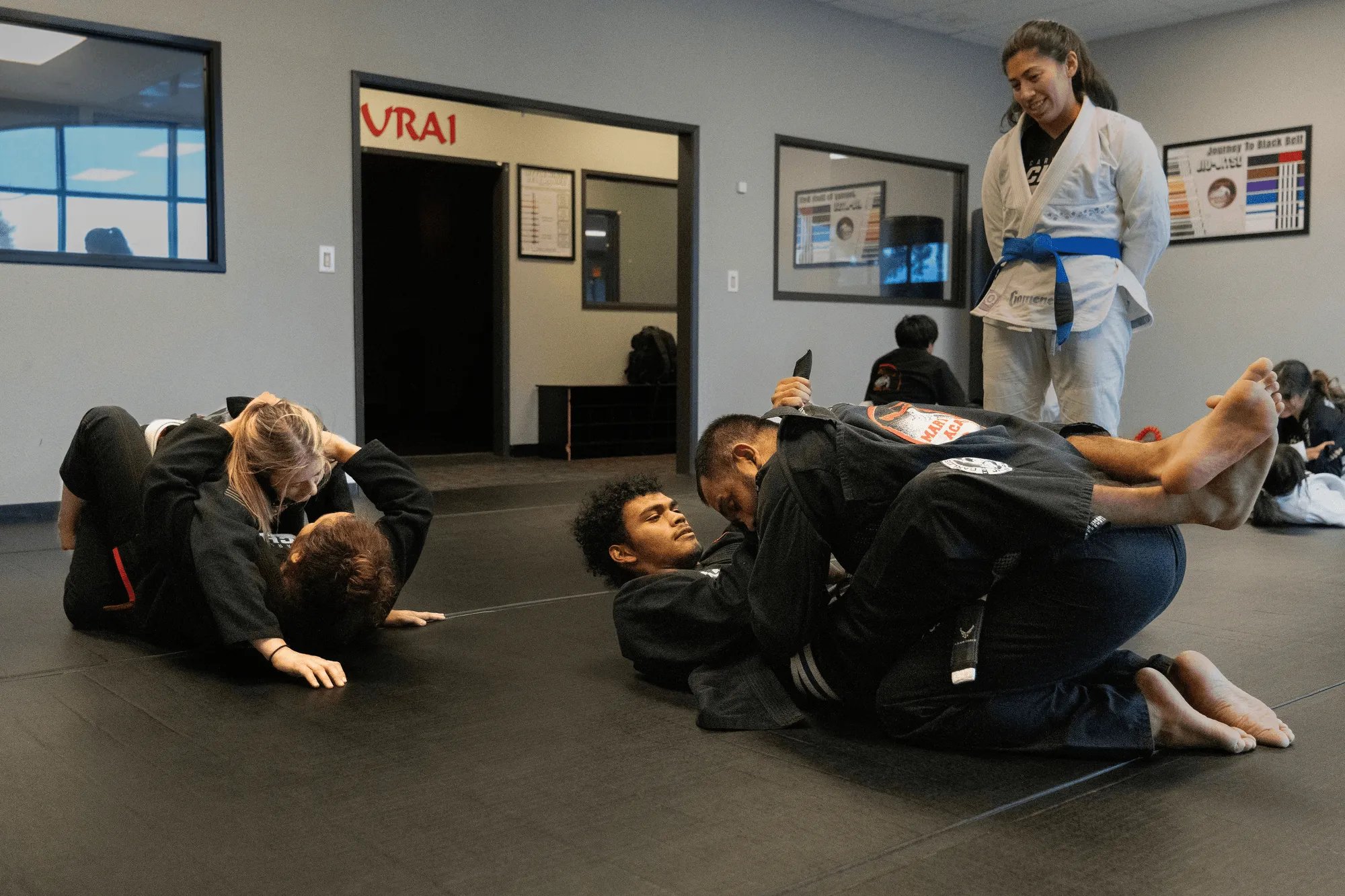 An adult Brazilian Jiu-Jitsu student's bare feet and white gi pants on the blue training mat at Guido's Martial Arts Academy in Clovis, CA
