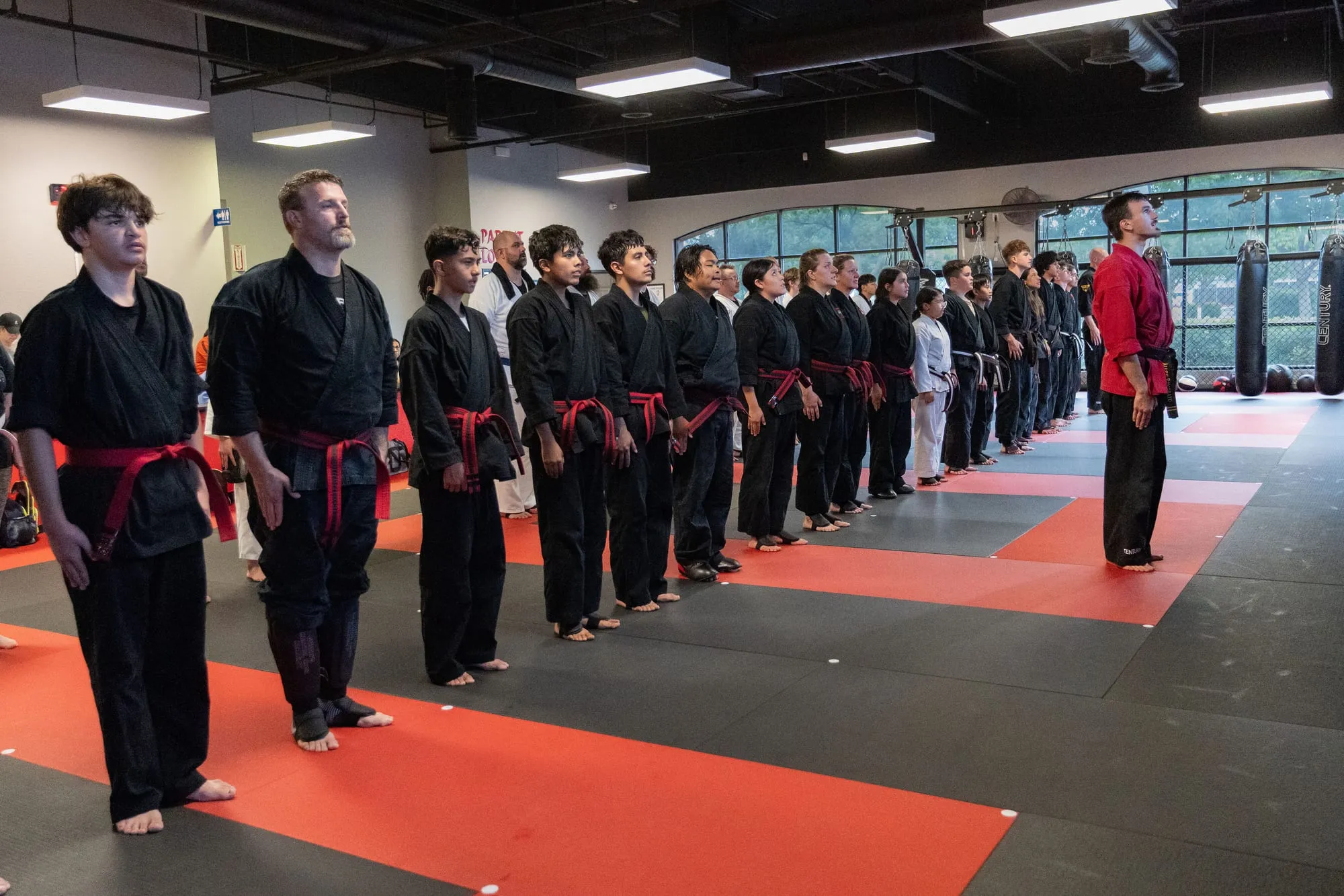 Full school group photo of students of all ages and ranks with instructors in front of the Guido's Martial Arts Academy wall in Clovis