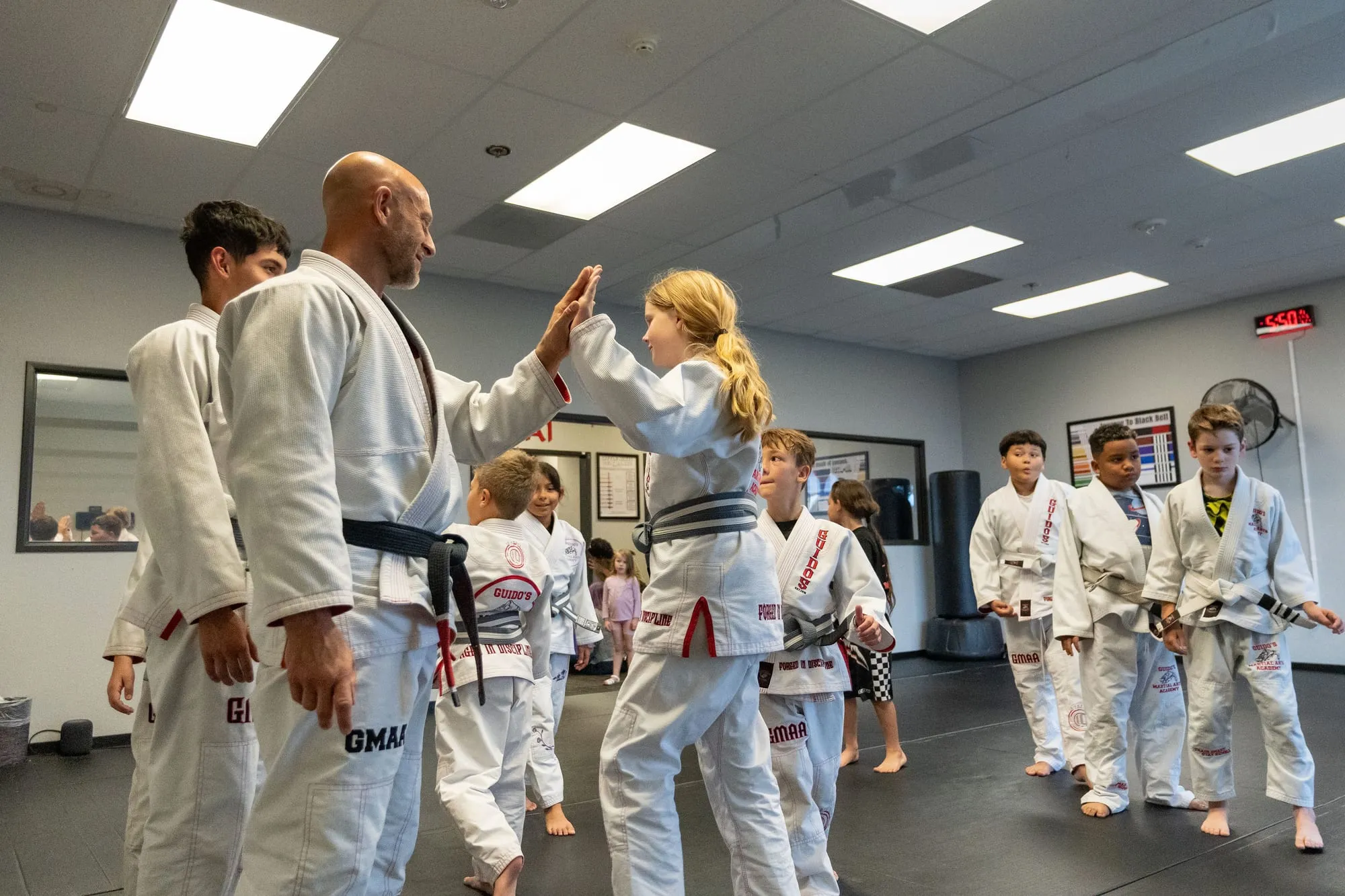 Shihan Mike Guido high-fiving a young student during a kids class at Guido's Martial Arts Academy in Clovis