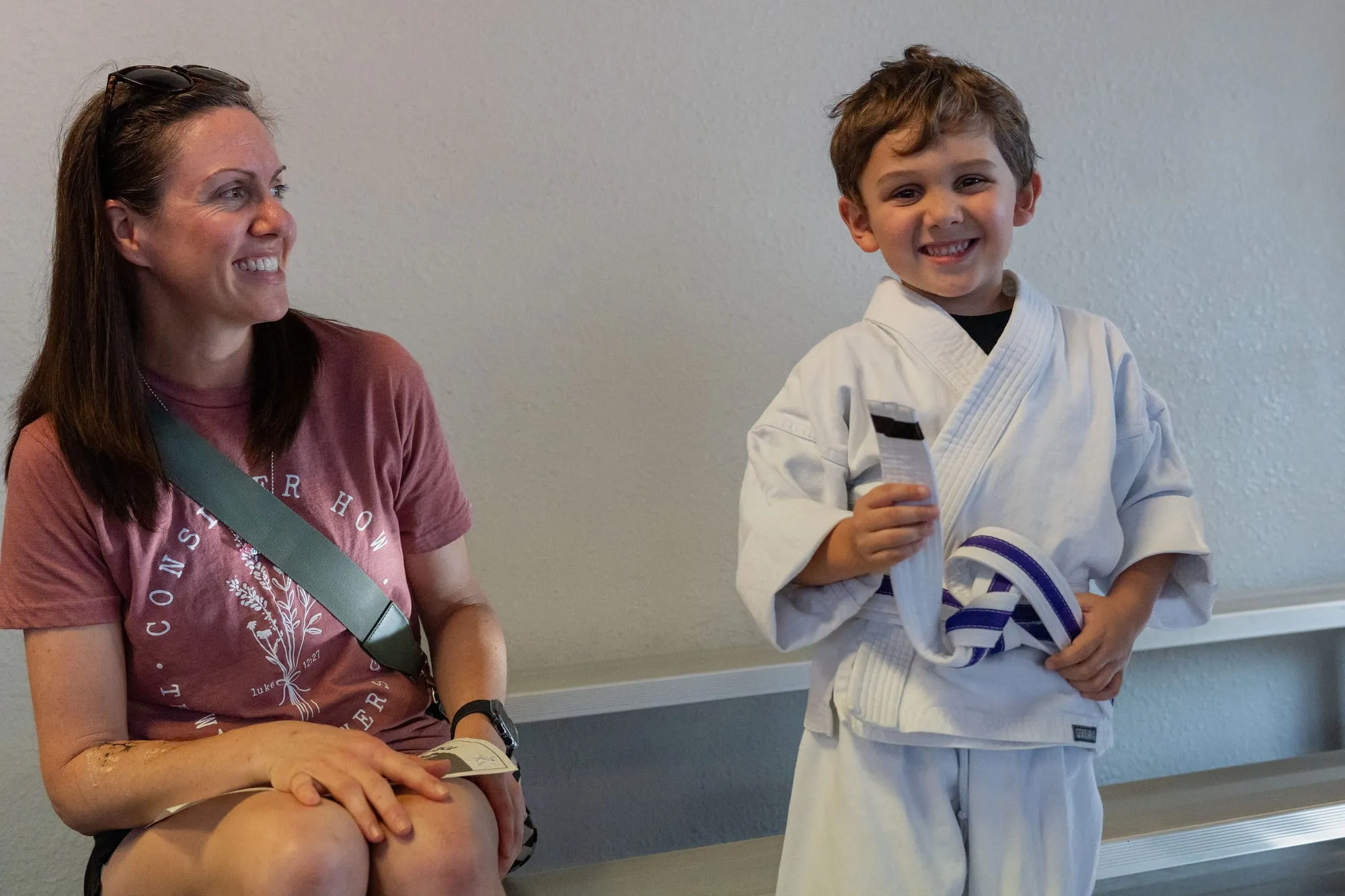 Parent sitting with her young son as he holds his belt at Guido's Martial Arts Academy in Clovis