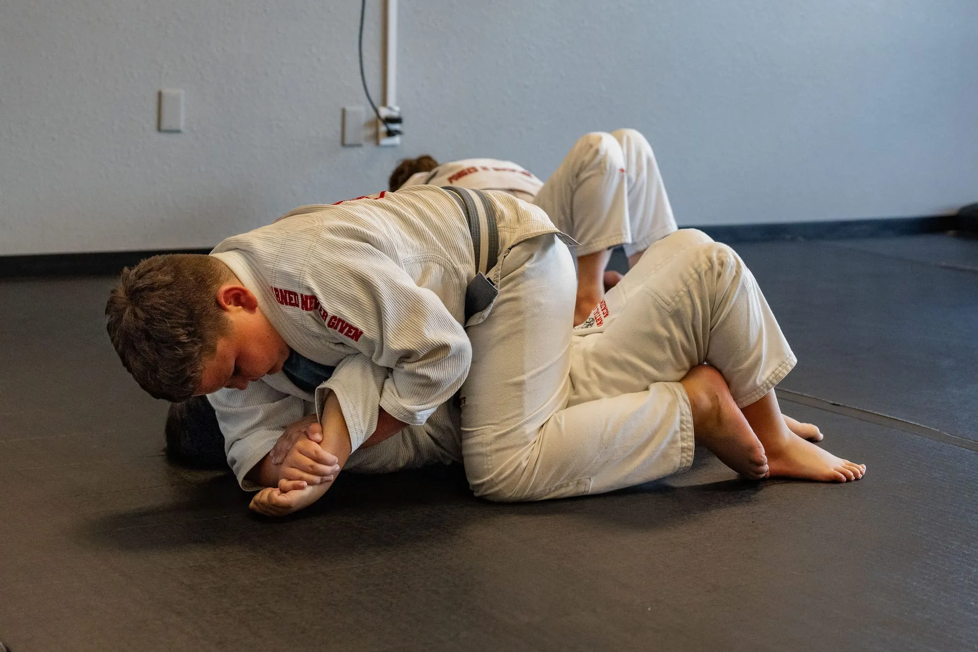 Two Juniors BJJ students with blue belts smiling at Guido's Martial Arts Academy in Clovis
