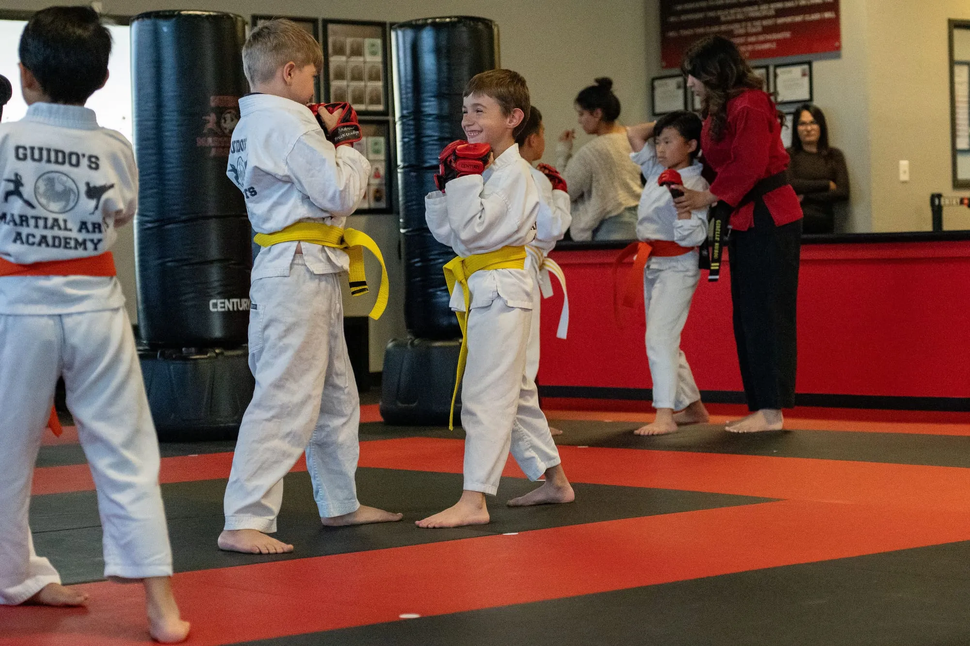 Young student throwing a front kick on a pad, standing tall and confident, at Guido's Martial Arts Academy in Clovis