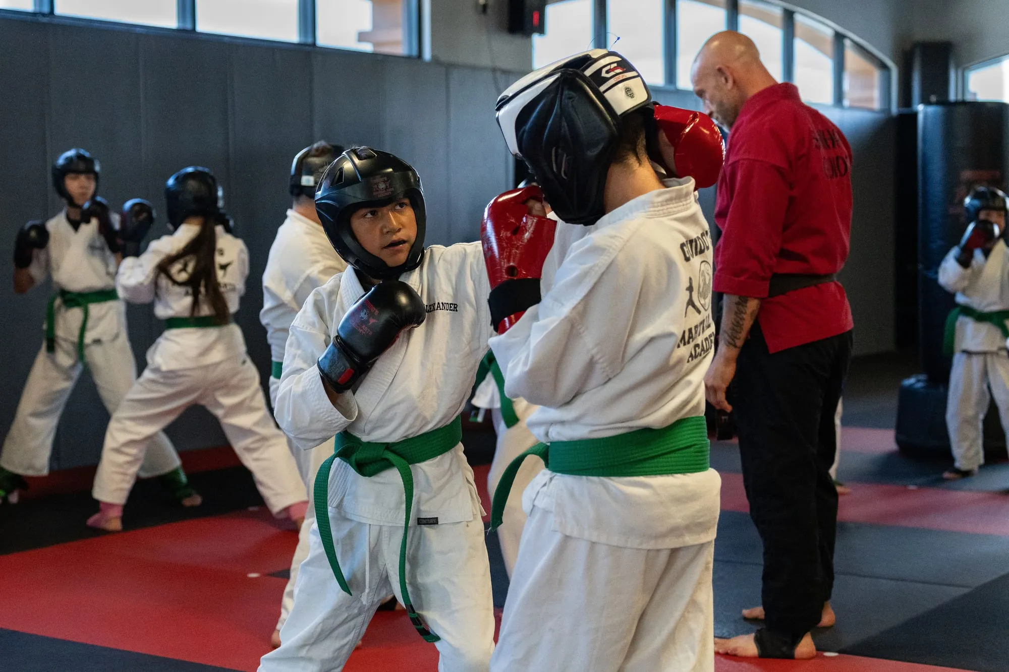 Young students sparring with headgear and gloves during a Juniors class at Guido's Martial Arts Academy in Clovis