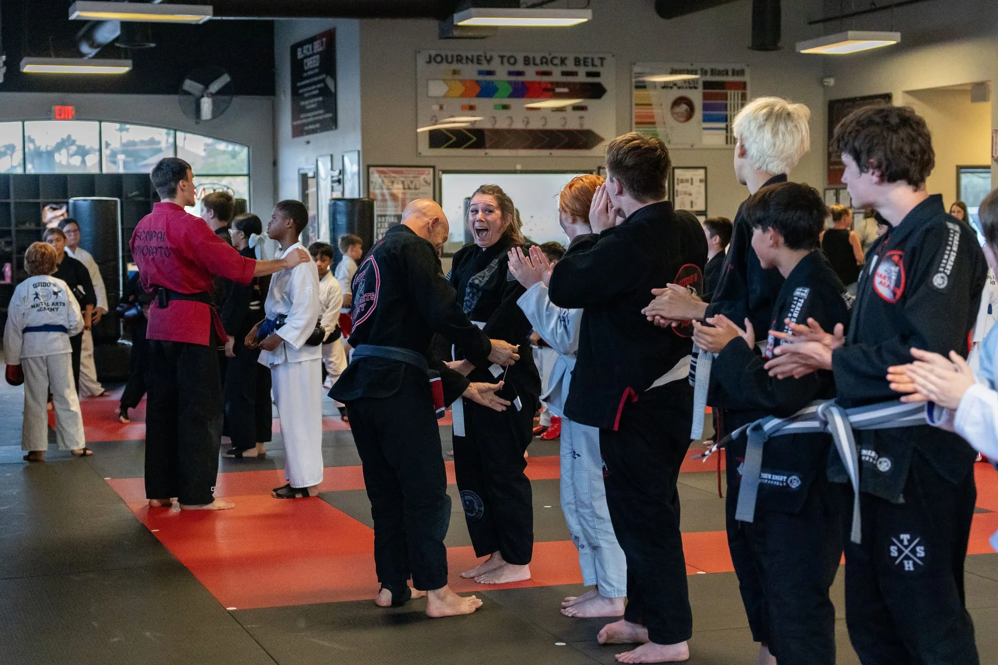 A student celebrated by clapping teammates at a belt promotion at Guido's Martial Arts Academy in Clovis