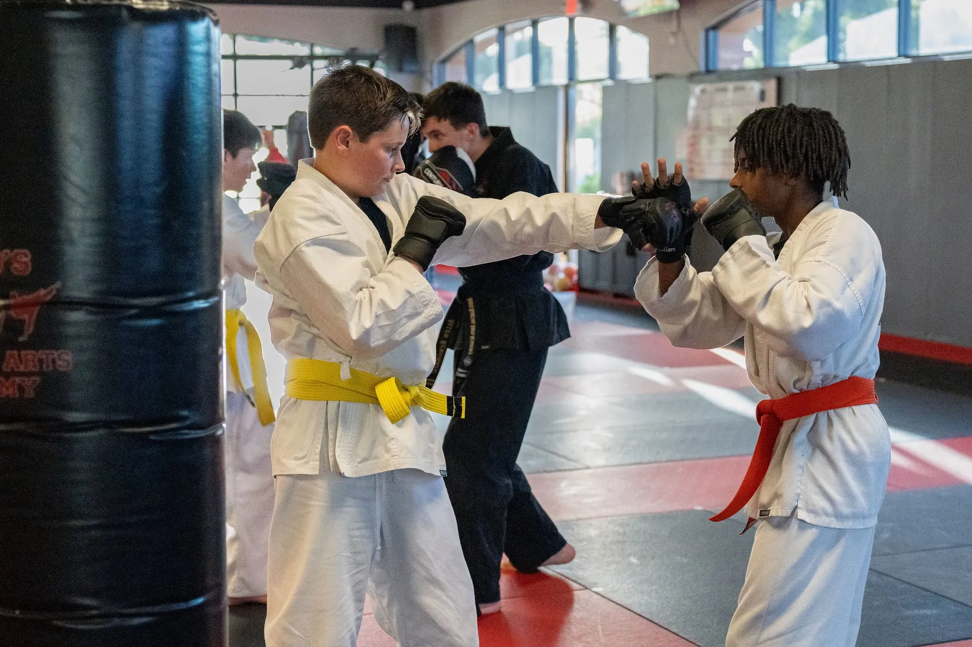 Teen and adult students doing MMA pad work in Guido's Martial Arts Academy gear in Clovis